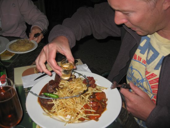 Matt pours flaming alcohol on his plate.