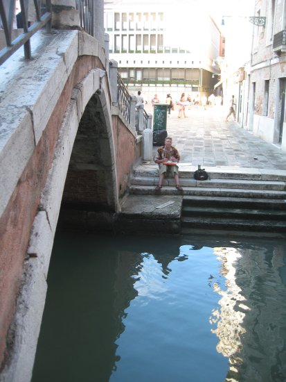 Matt eating pizza by the bridge