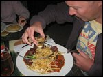 Matt pours flaming alcohol on his plate.